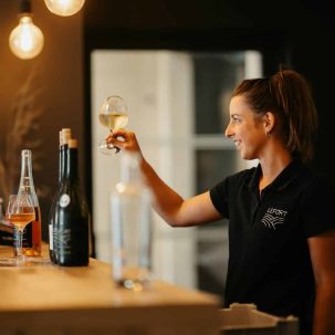 a woman is holding a glass of wine